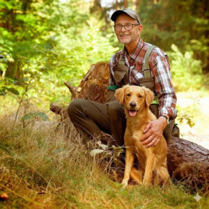 Glücklicher Mann mit Hund im Wald, Natur, Outdoor, Spaziergang, Hundeliebe.