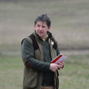 Mann mit Notizbuch bei Hunde-Event im Freien, Tierliebhaber.